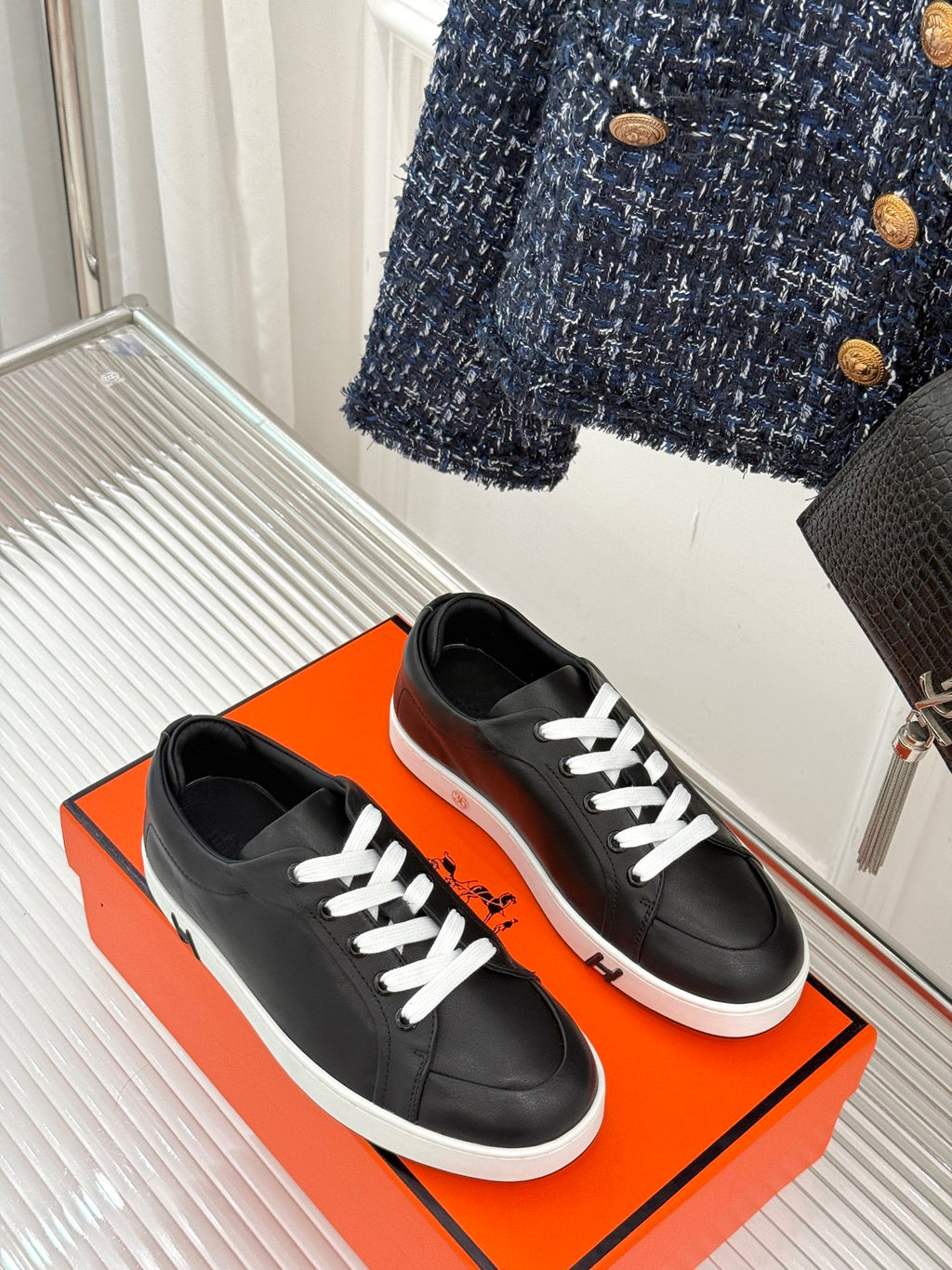 Black low-top sneakers with white laces and low white rubber sole, side-by-side view.