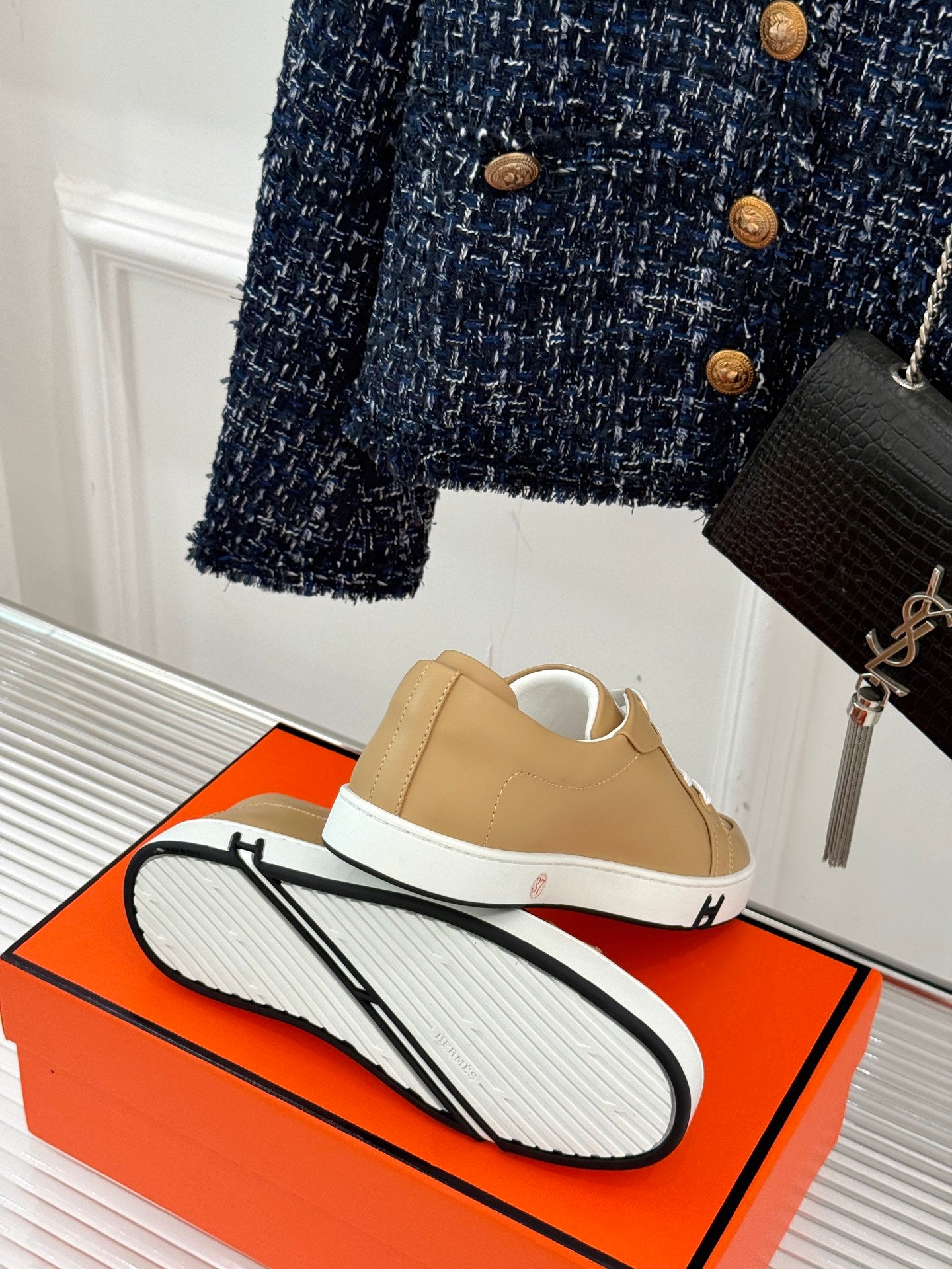 Back view of ladies' Hermes sneakers, tan leather with white laces and grippy sole