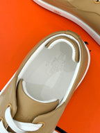 Tan Hermes sneaker interior with white laces and cushioned collar lining