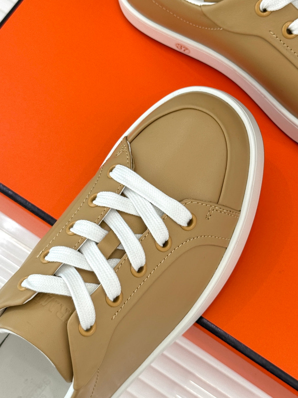 Single ladies' Hermes sneaker, tan leather with white laces and white rubber sole