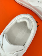 White leather sneaker interior with stitched collar and lace opening.