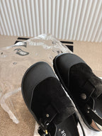Unisex Dior black shoes close-up of wide strap and gold-toned button hardware