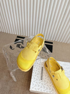 Yellow unisex shoes with adjustable buckles, front angle on shoebox