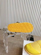 Yellow unisex shoes outsole close-up on chair, textured tread pattern