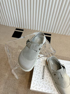 Light gray slip-on shoes with buckle strap on top and side view