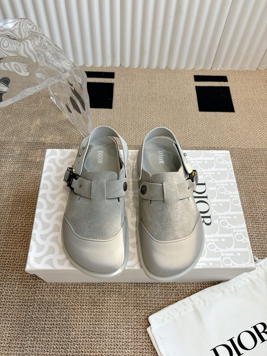 Light gray slip-on shoes with buckled strap and stitched toe cap