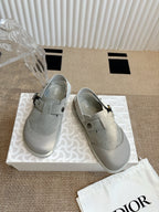 Pair of light gray slip-on shoes with adjustable buckled strap