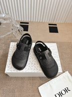Pair of black and dark gray slip-on shoes with felt panels and buckle strap