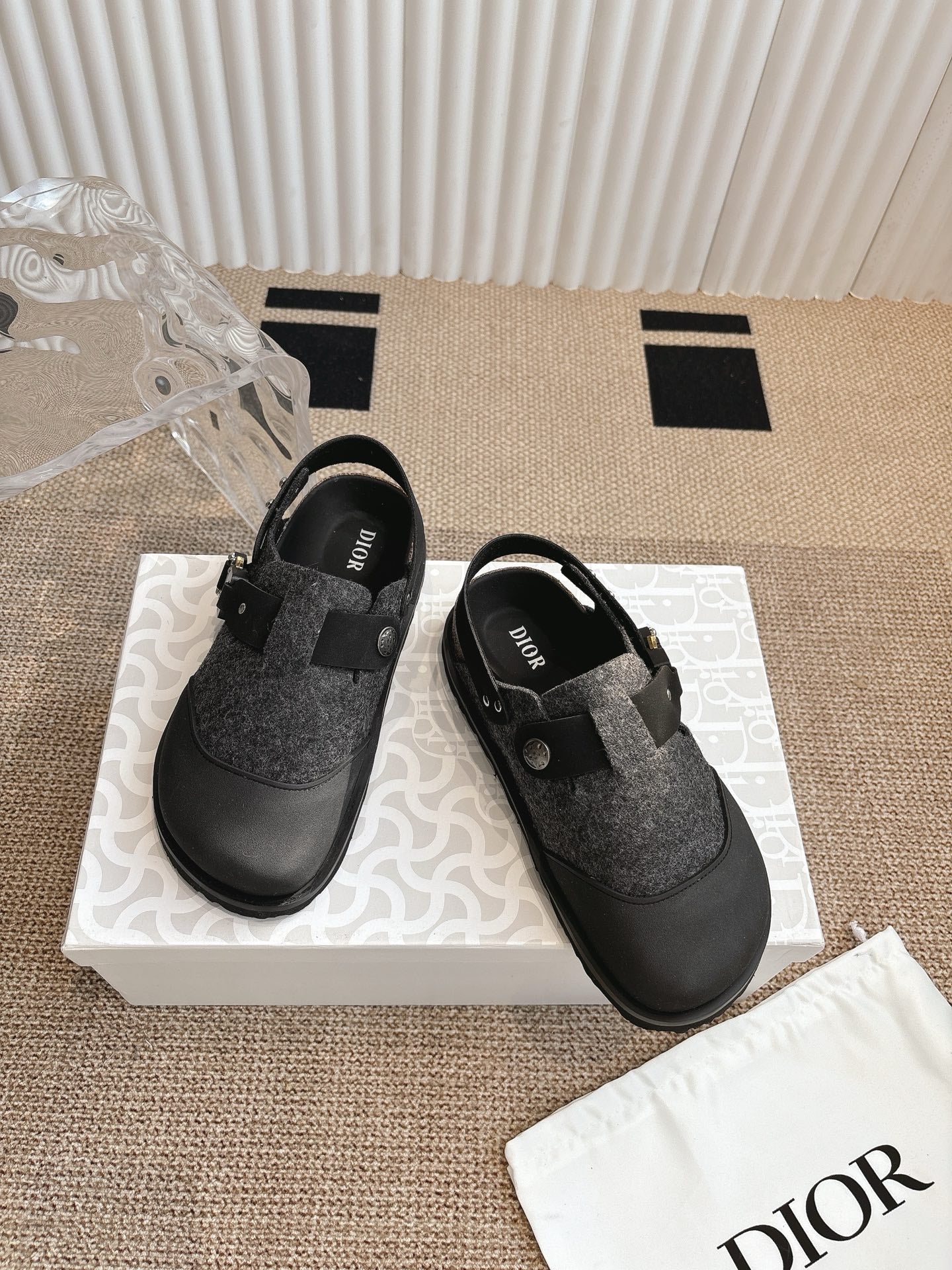 Pair of black and dark gray slip-on shoes with felt panels and buckle strap