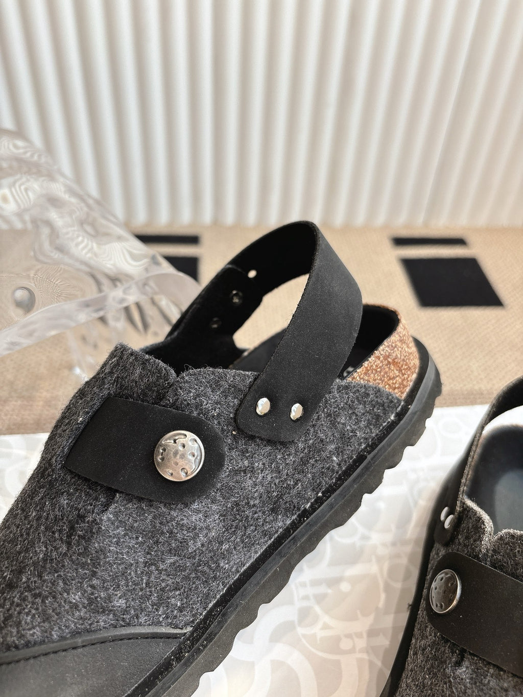 Black and dark gray slip-on sandal with felt upper and round decorative buckle