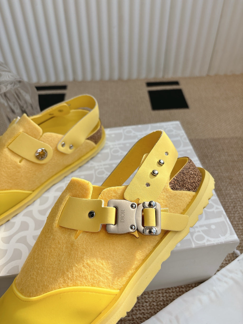 Dior unisex yellow slip-on shoes with silver buckle on strap, close angle