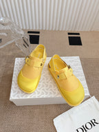 Dior unisex yellow slip-on shoes on box, side view with buckle strap