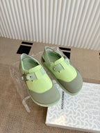 Unisex green sneakers with two straps and buckles, paired on the box