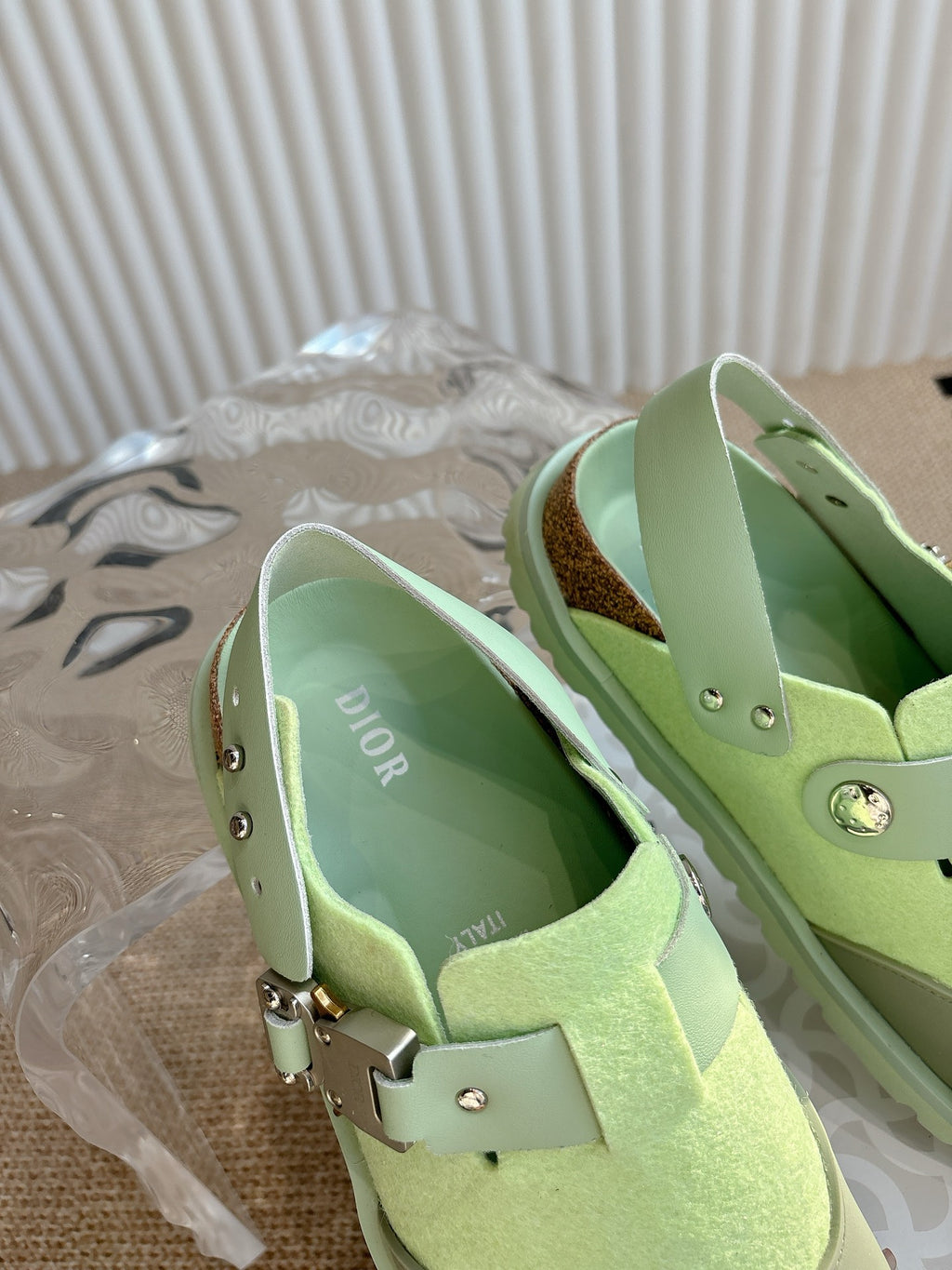 Unisex green sneakers with interior lining and metal strap hardware, close-up