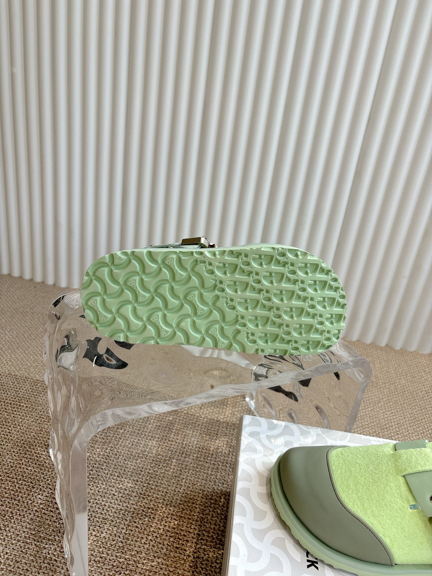 Unisex green sneaker outsole with textured tread, side profile under cover