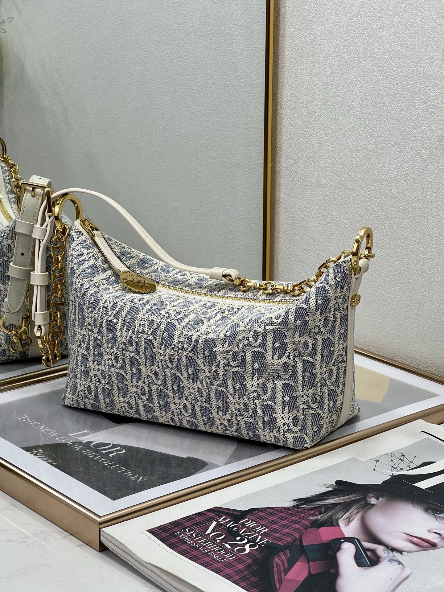 Medium shoulder bag in blue-and-white monogram canvas, gold chain strap with white handles.