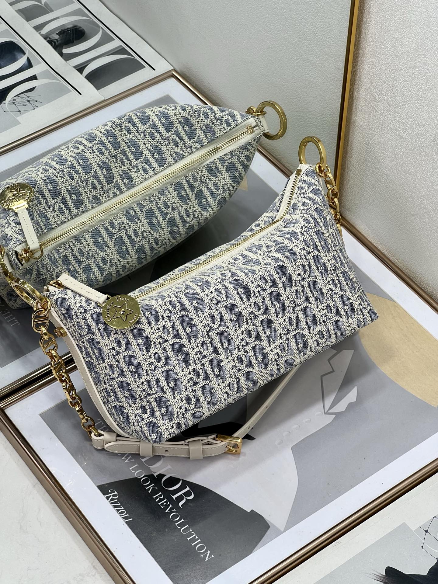 Small crossbody bag with blue-and-white monogram print, gold hardware, curb chain strap.