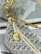Close-up of monogram hobo bag with gold chain, zipper pull, and star emblem charm.