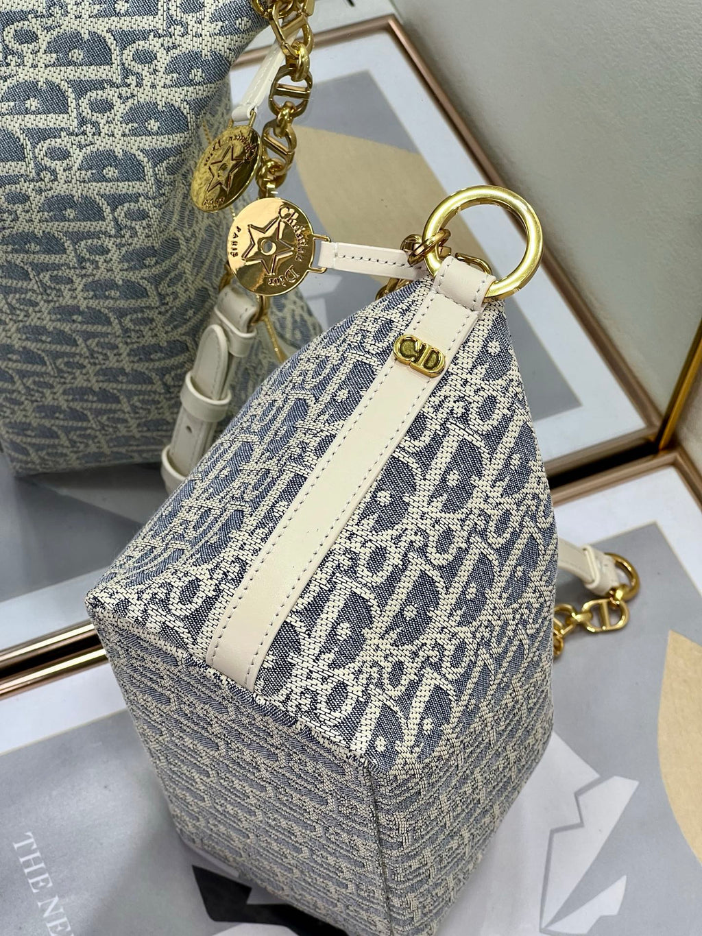 Structured mini bag with blue-and-white monogram print, white stripe panel, gold ring strap.