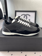 Black Chanel low-top sneakers, side view with white laces and CC emblem