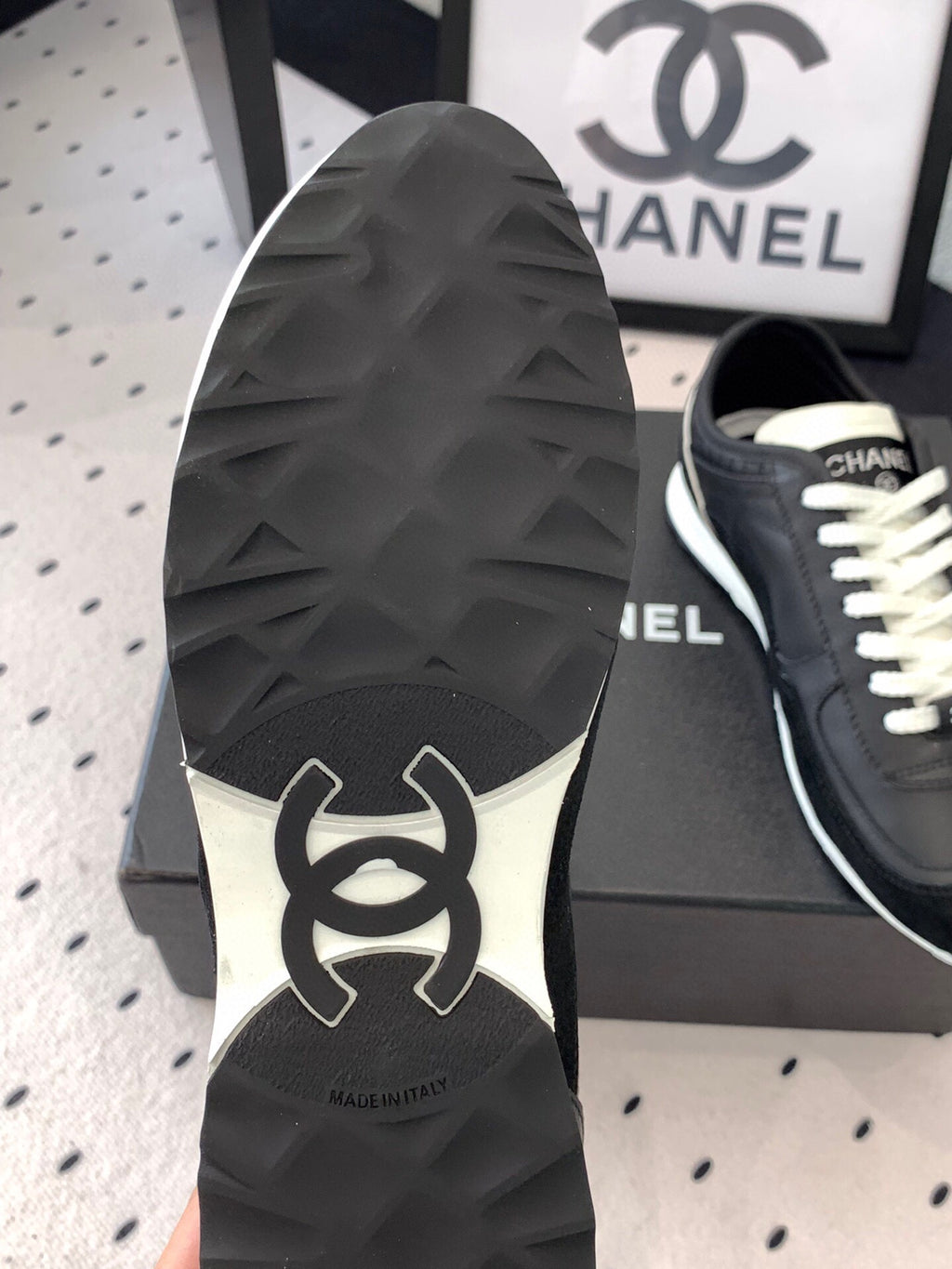 Chanel sneaker outsole with dark tread pattern and white CC logo