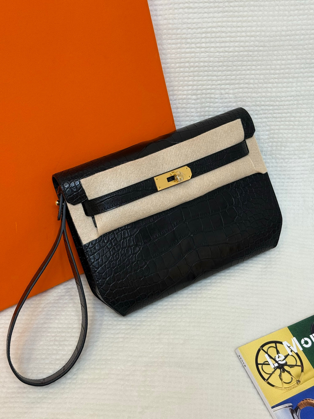 Hermes croc-embossed flap bag, angled view, gold turn-lock clasp and long strap.