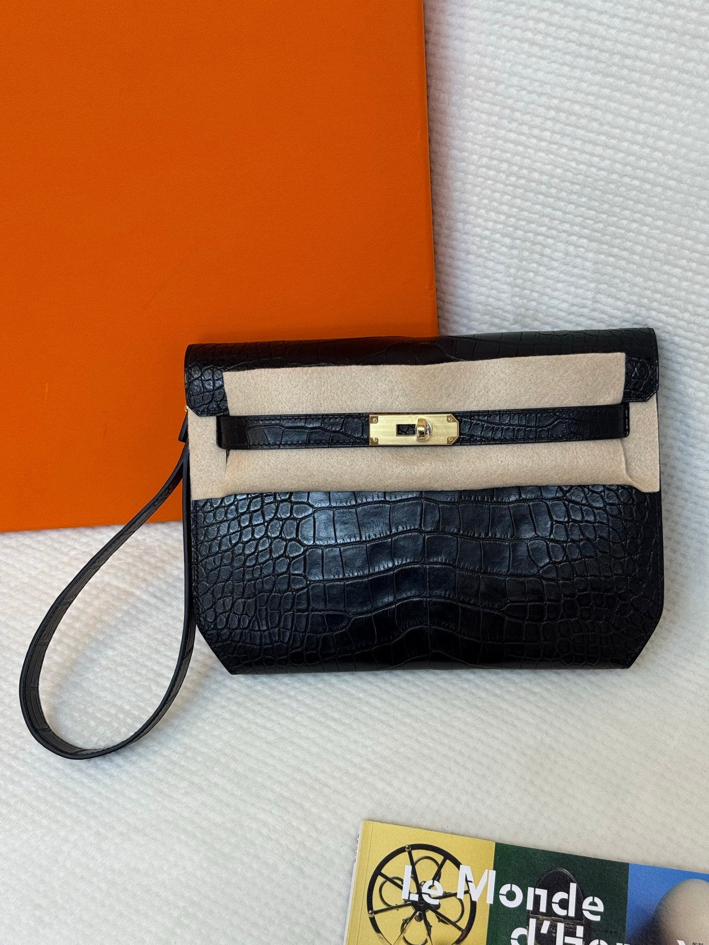 Hermes croc-embossed flap bag with gold turn-lock clasp and shoulder strap.