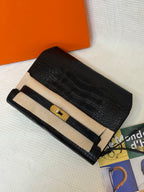 Hermes croc-embossed flap bag with beige top band, gold turn-lock, and long strap.