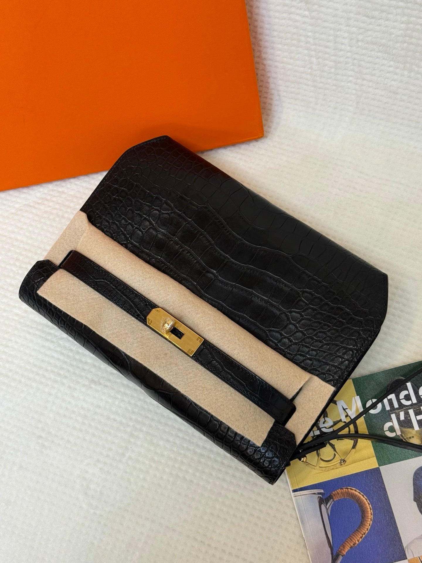Hermes croc-embossed flap bag with beige top band, gold turn-lock, and long strap.