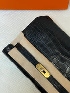 Hermes croc-embossed flap bag close-up with gold clasp and beige insert panel.