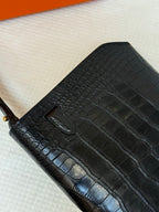 Hermes croc-embossed leather flap bag texture close-up with stitched seam.