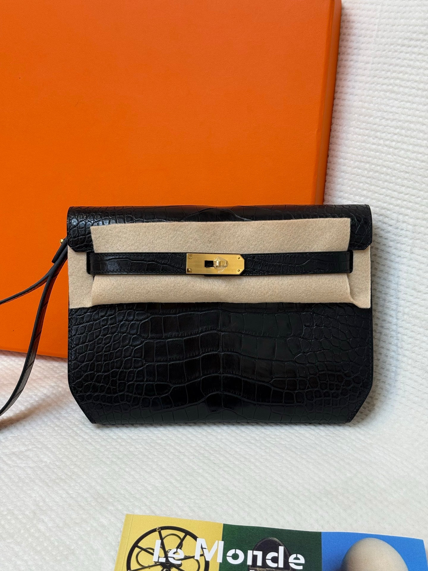 Hermes croc-embossed flap bag with beige interior flap, gold clasp, and crossbody strap.