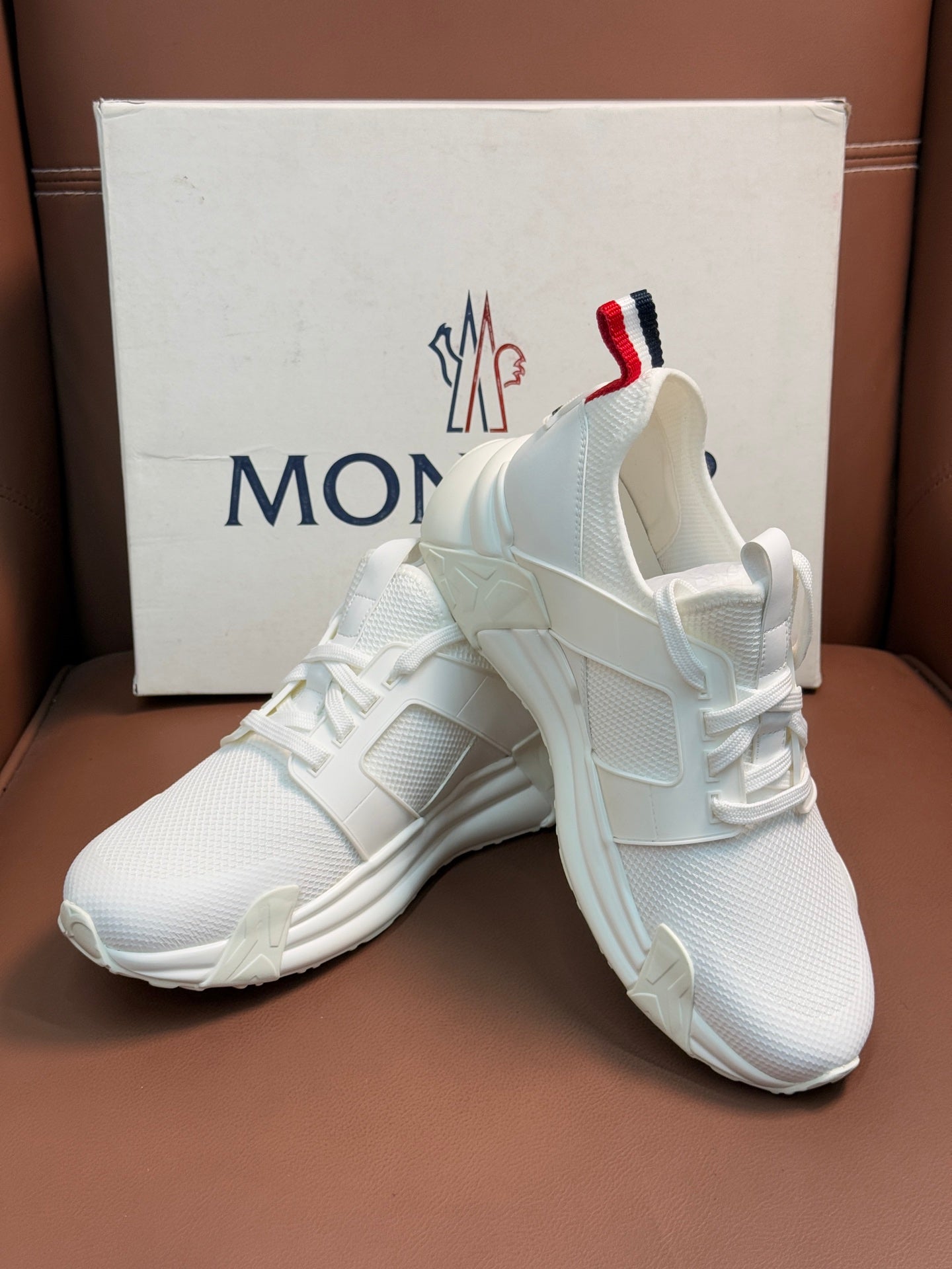 Moncler white lace-up sneakers, angled view, cushioned collar and sole