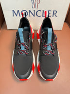 Moncler luxury shoes with black upper, red side accents, and light blue heel pull tab