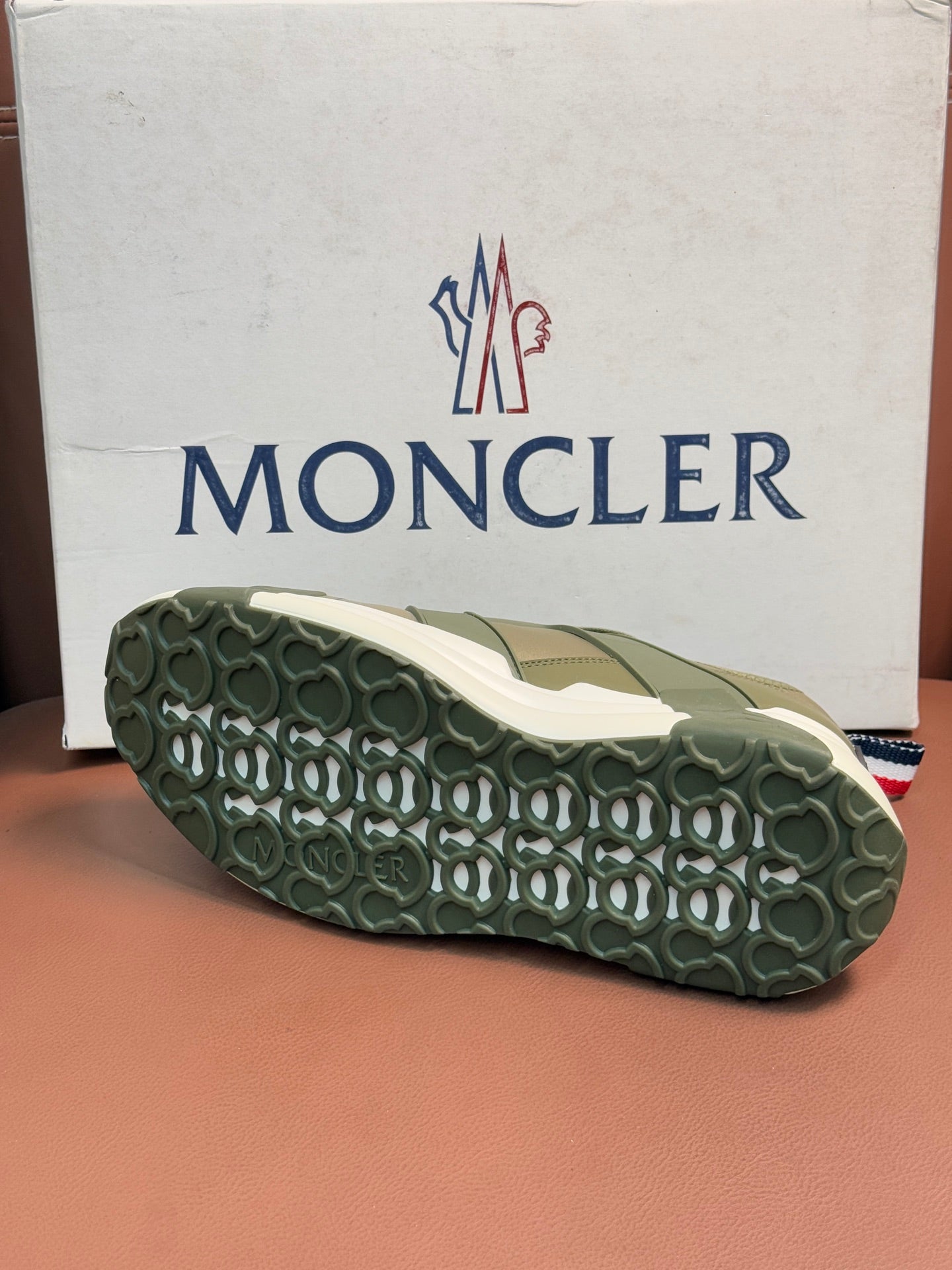 Moncler luxury sneaker outsole with textured olive tread and off-white edge