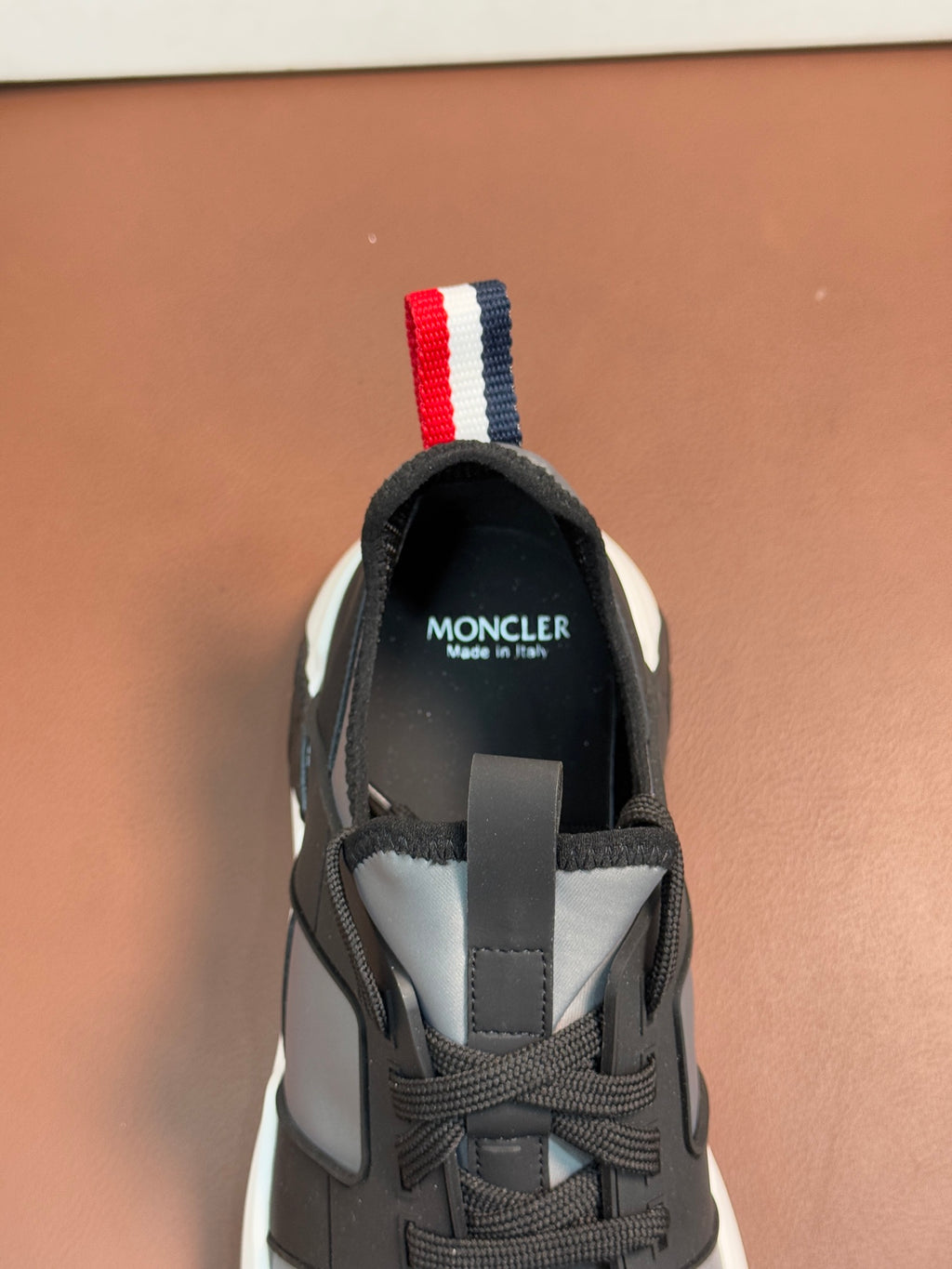 Moncler lace-up sneakers heel view with tricolor striped pull tab