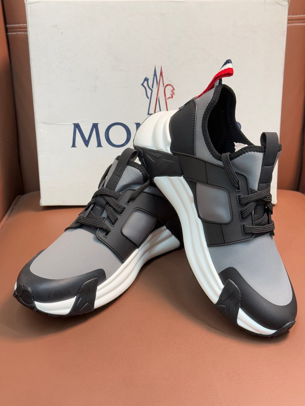 Moncler lace-up sneakers with black-and-gray uppers and red-white heel accents