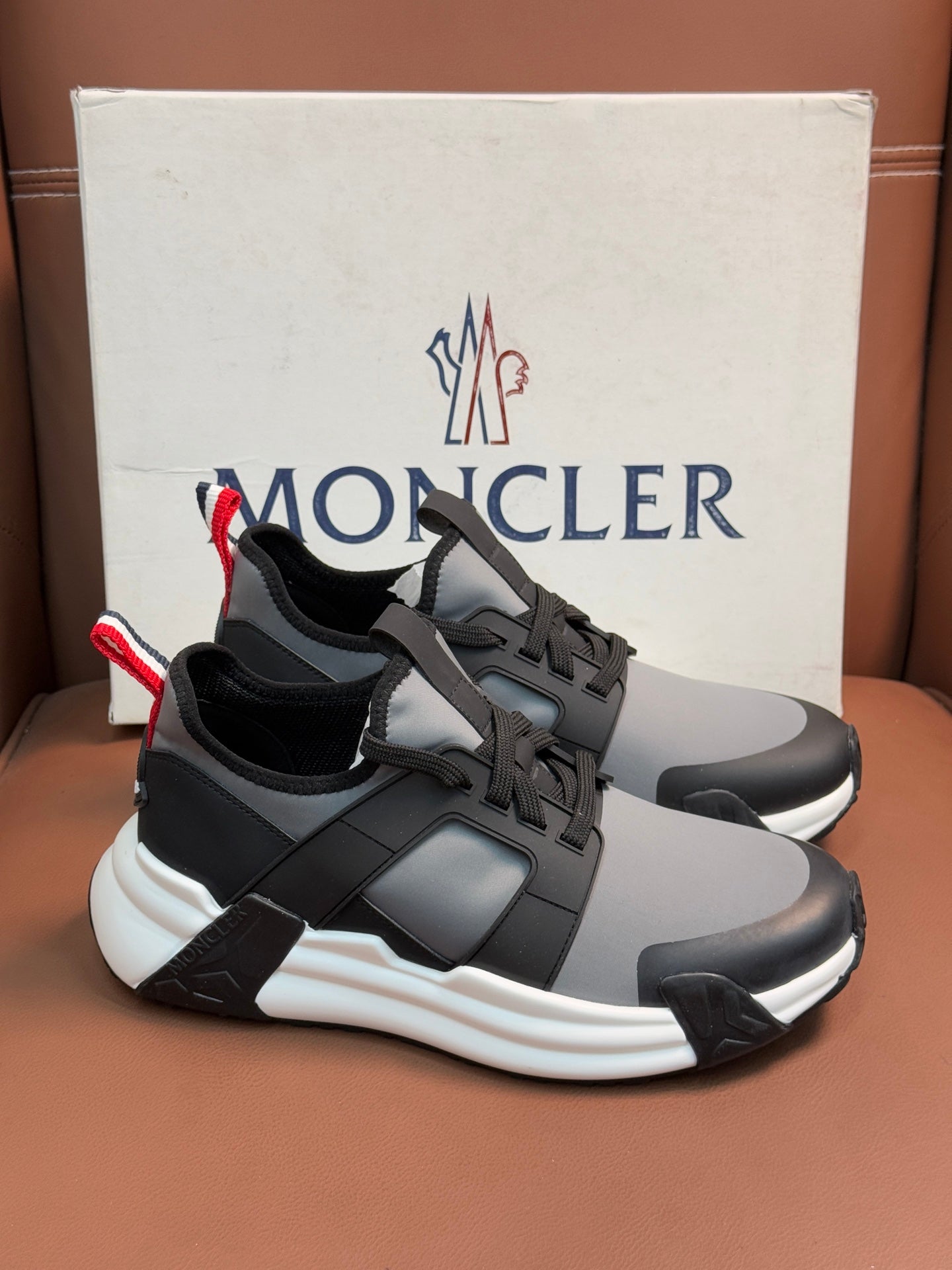 Moncler lace-up sneakers in gray and black with red-white striped heel tabs