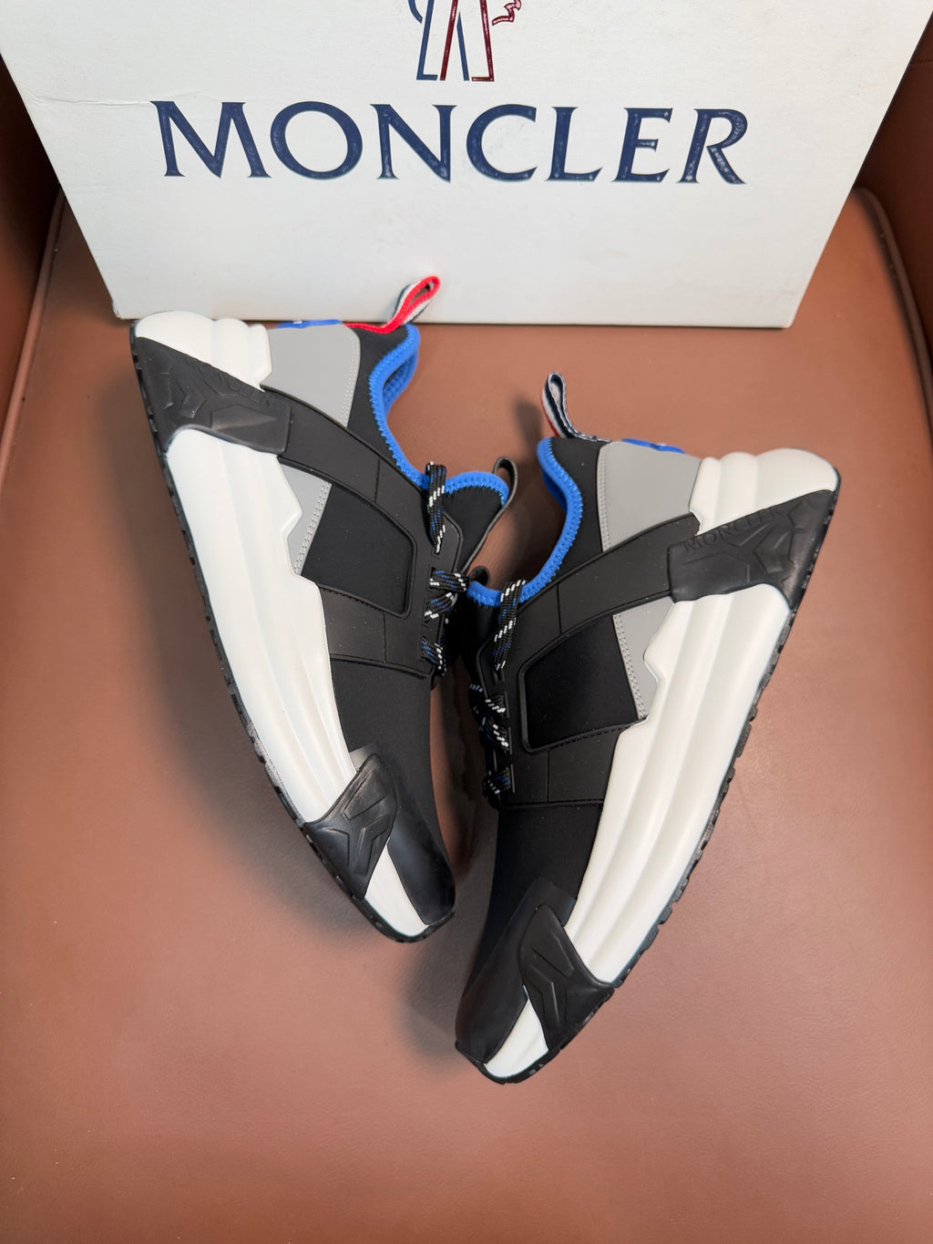 Moncler black sneakers with blue and white panels, red/blue pull-tab, chunky sole