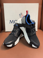 Moncler black sneakers with white midsoles and blue/red pull tabs, lace-up front