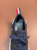 Luxury sneaker heel view with lace-up lacing, dark navy upper, and striped pull tab
