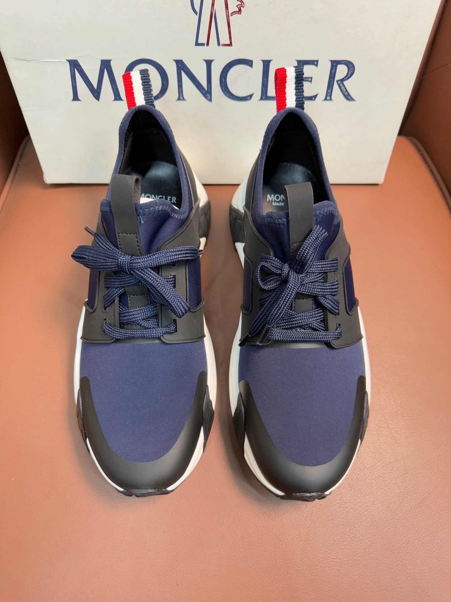 Luxury sneakers in dark navy with lace-up front and cushioned white sole