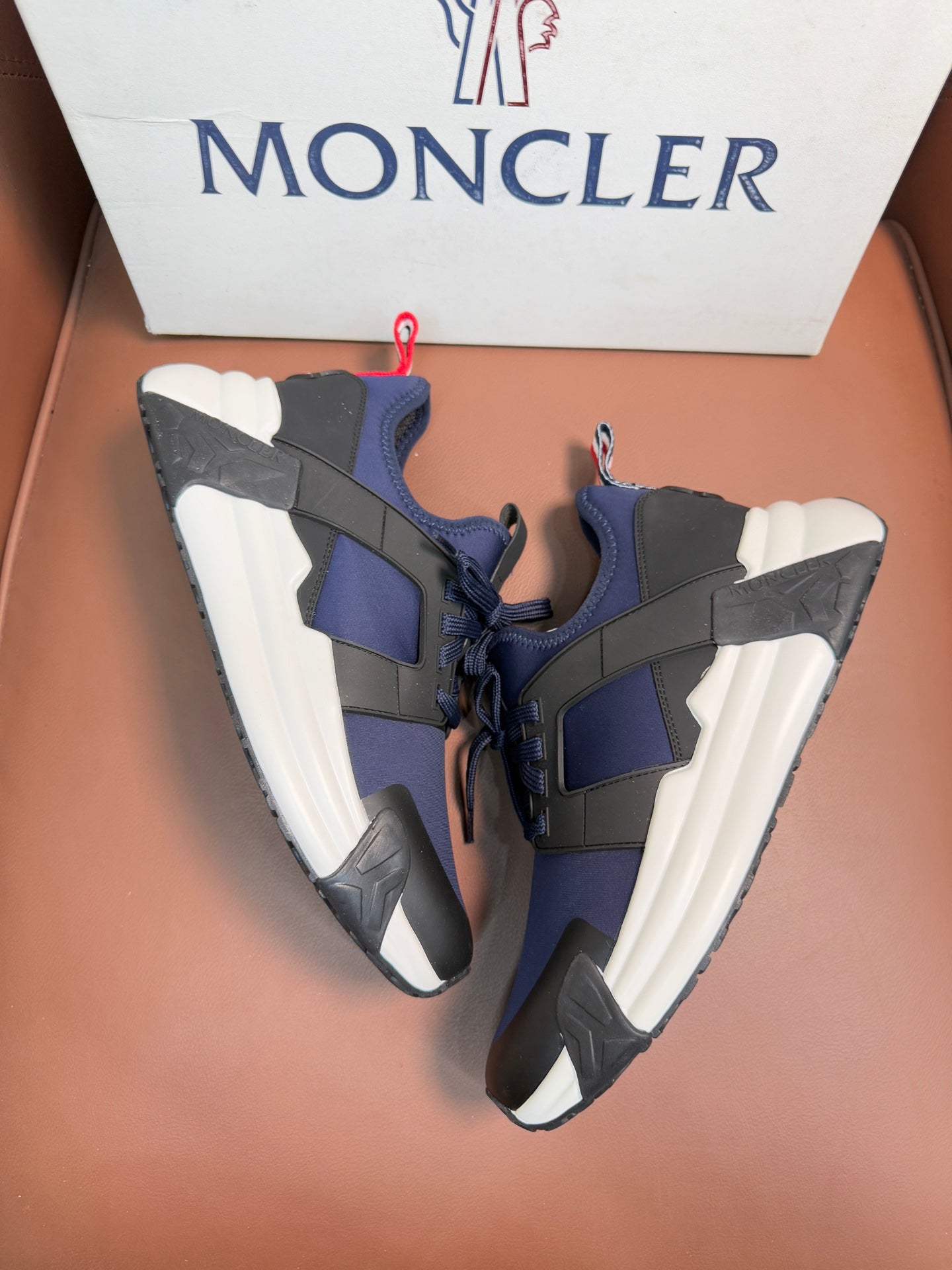 Luxury sneakers with lace-up front, dark navy uppers, contrast panels, white soles