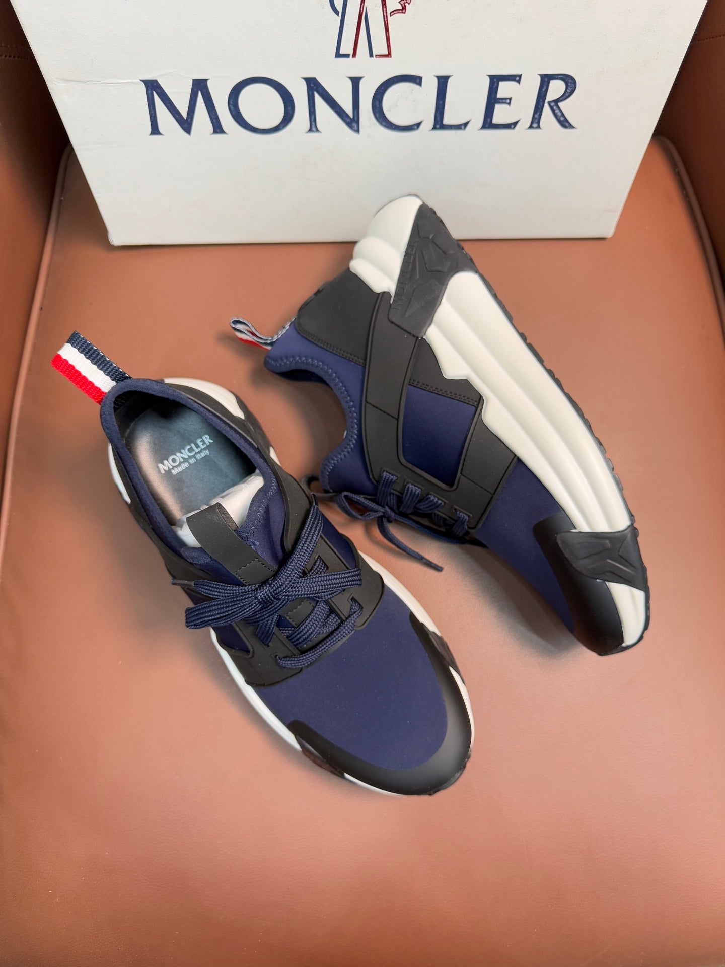 Luxury sneakers, dark navy with lace-up closure, white midsole, side panel detail
