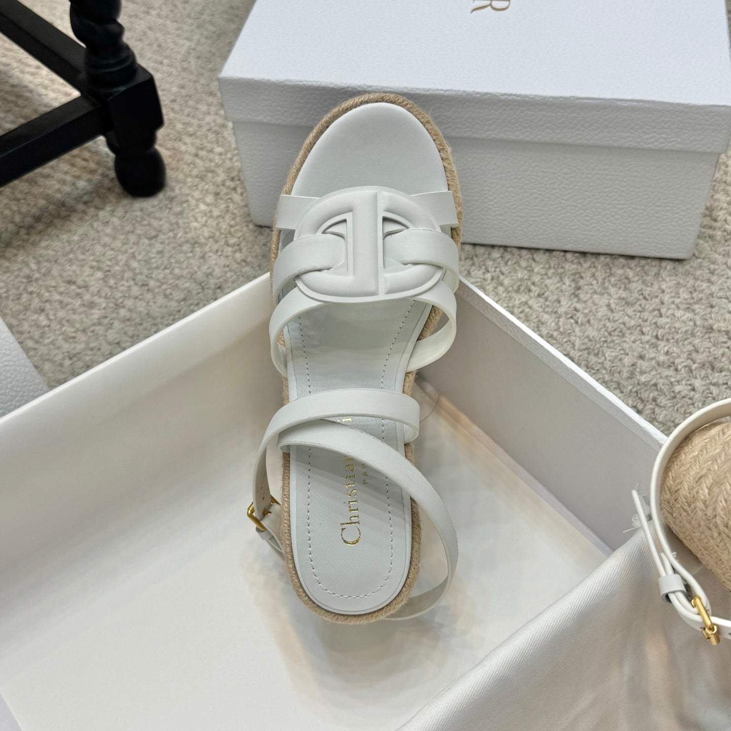 Espadrille wedge sandals, close-up of white straps and gold-tone buckle on heel
