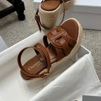 Tan espadrille platform slide sandals with knotted crossover straps and buckle