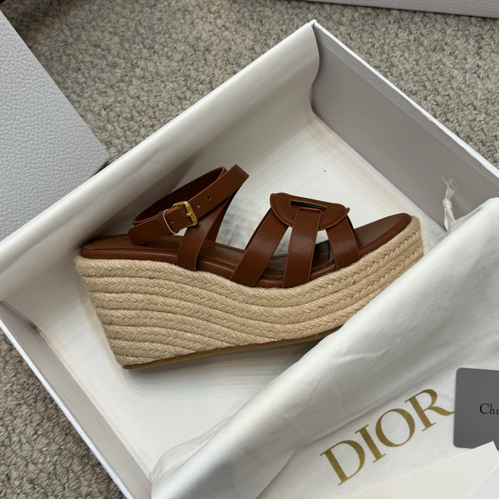 Beige espadrille wedge sandals with brown leather straps and buckle closure