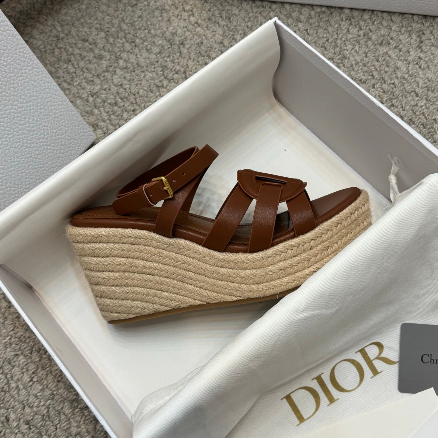 Beige espadrille wedge sandals with brown leather straps and buckle closure