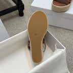 Tan sandal outsole and espadrille wedge heel, shown in display box