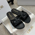 Dior black slide sandals with wide double straps and gold logo on footbed